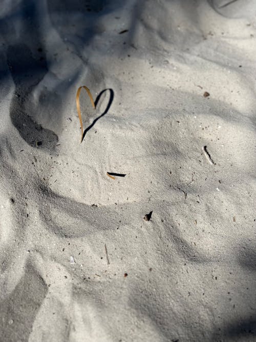 A heart is drawn in the sand on a beach
