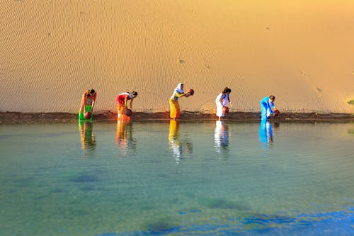 Cinco Mujeres Obteniendo Agua De Un Cuerpo De Agua