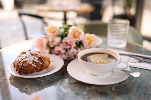 Free A cup of coffee and a pastry on a table Stock Photo