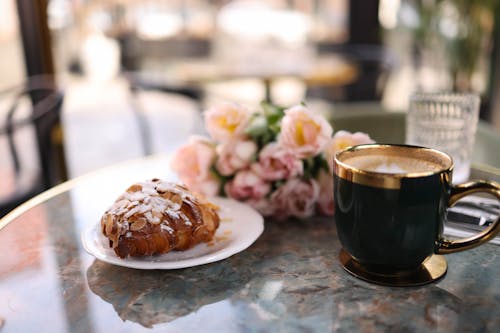 Free A coffee cup and pastry on a table Stock Photo