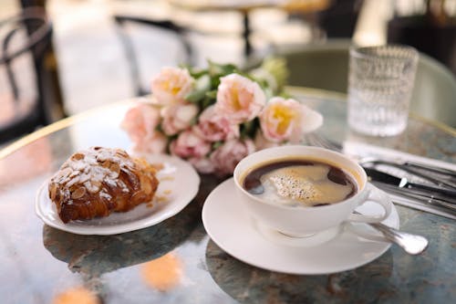 Free A cup of coffee and a pastry on a table Stock Photo