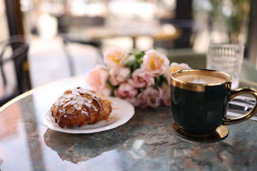 Free A coffee cup and pastry on a table Stock Photo