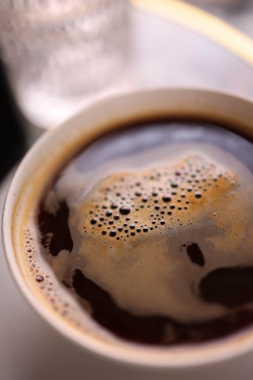 A close up of a cup of coffee with bubbles