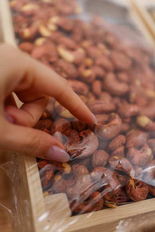 A person is putting nuts into a plastic container
