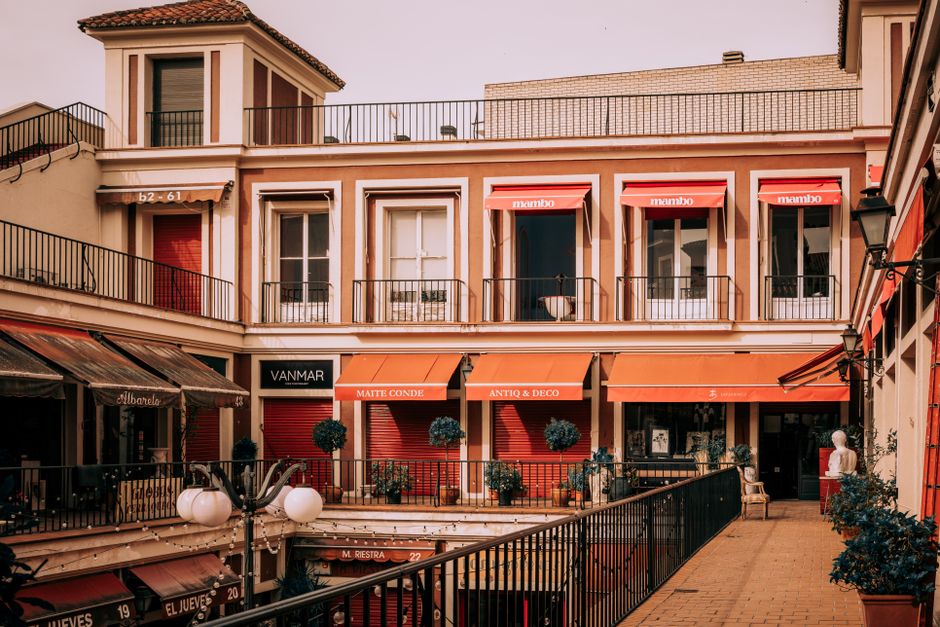 Hermoso patio urbano en Madrid con toldos vibrantes y tiendas locales.