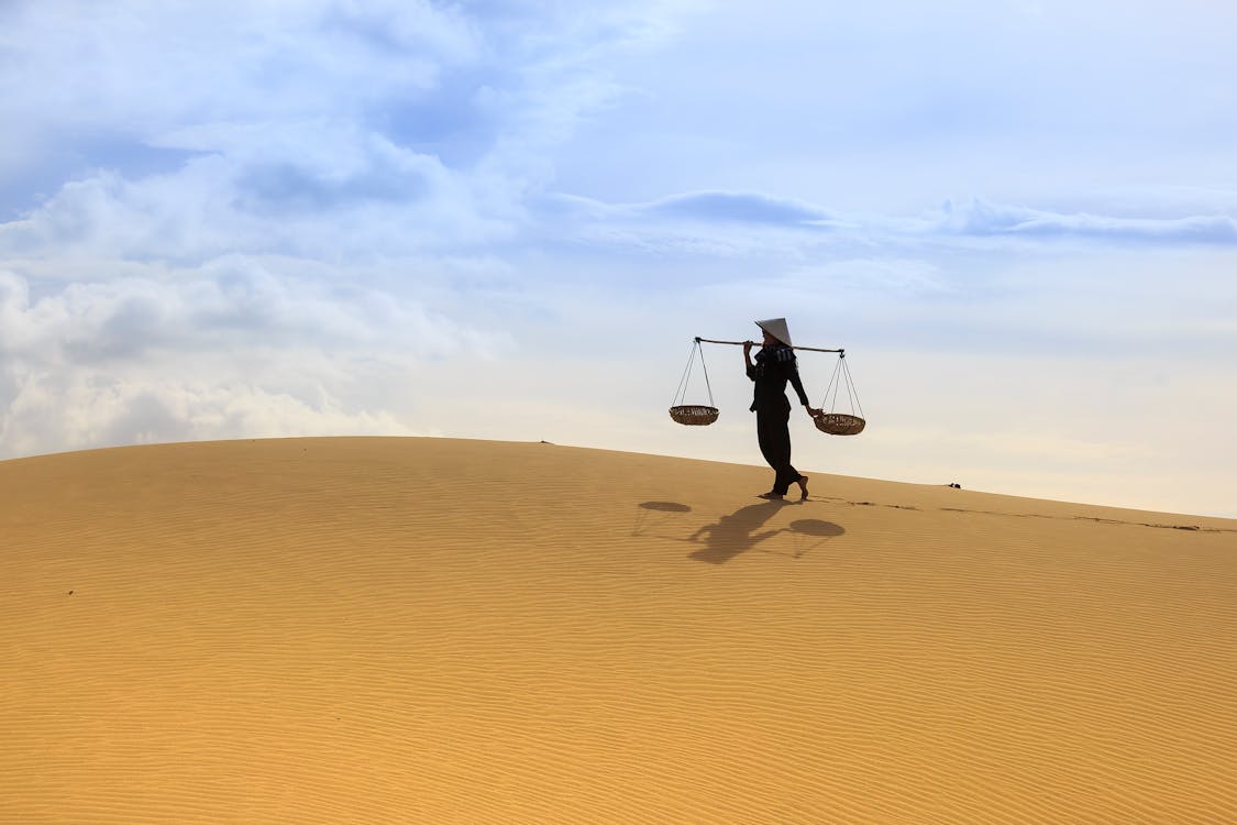 Женщина, держащая ярмо, несущая ярмо в пустыне