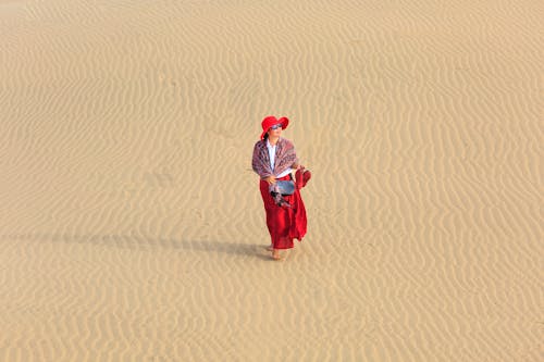 Femme Vêtue D'une Robe Rouge Marchant Sur Le Désert Vide