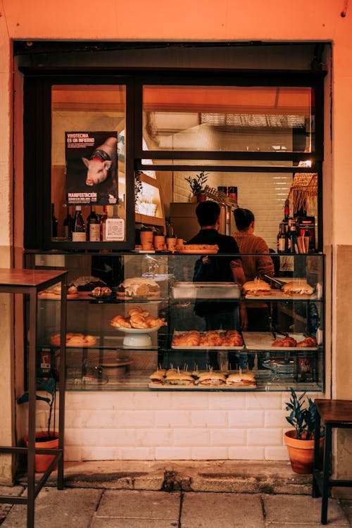 A bakery with a window and a man standing outside