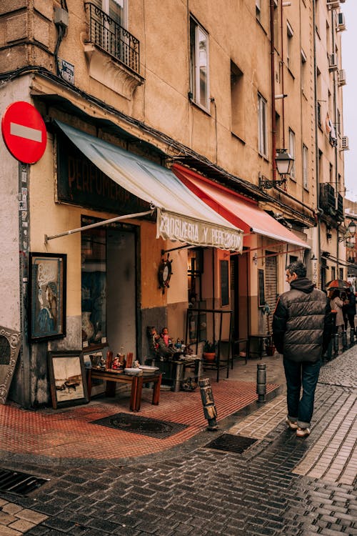 A man walking down a street with a red sign