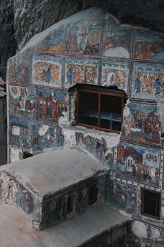 Weathered Byzantine frescoes adorn the walls of Sumela Monastery, showcasing intricate religious art.