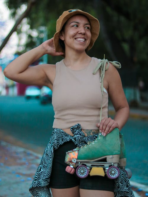 Free A woman in a hat and shorts holding a skateboard Stock Photo