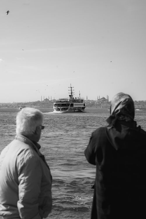 Free A black and white image of a senior couple watching a ferry in Kadıköy, Istanbul. Stock Photo
