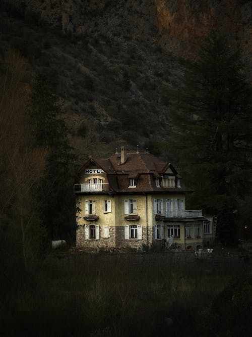 A house in the mountains with a dark sky