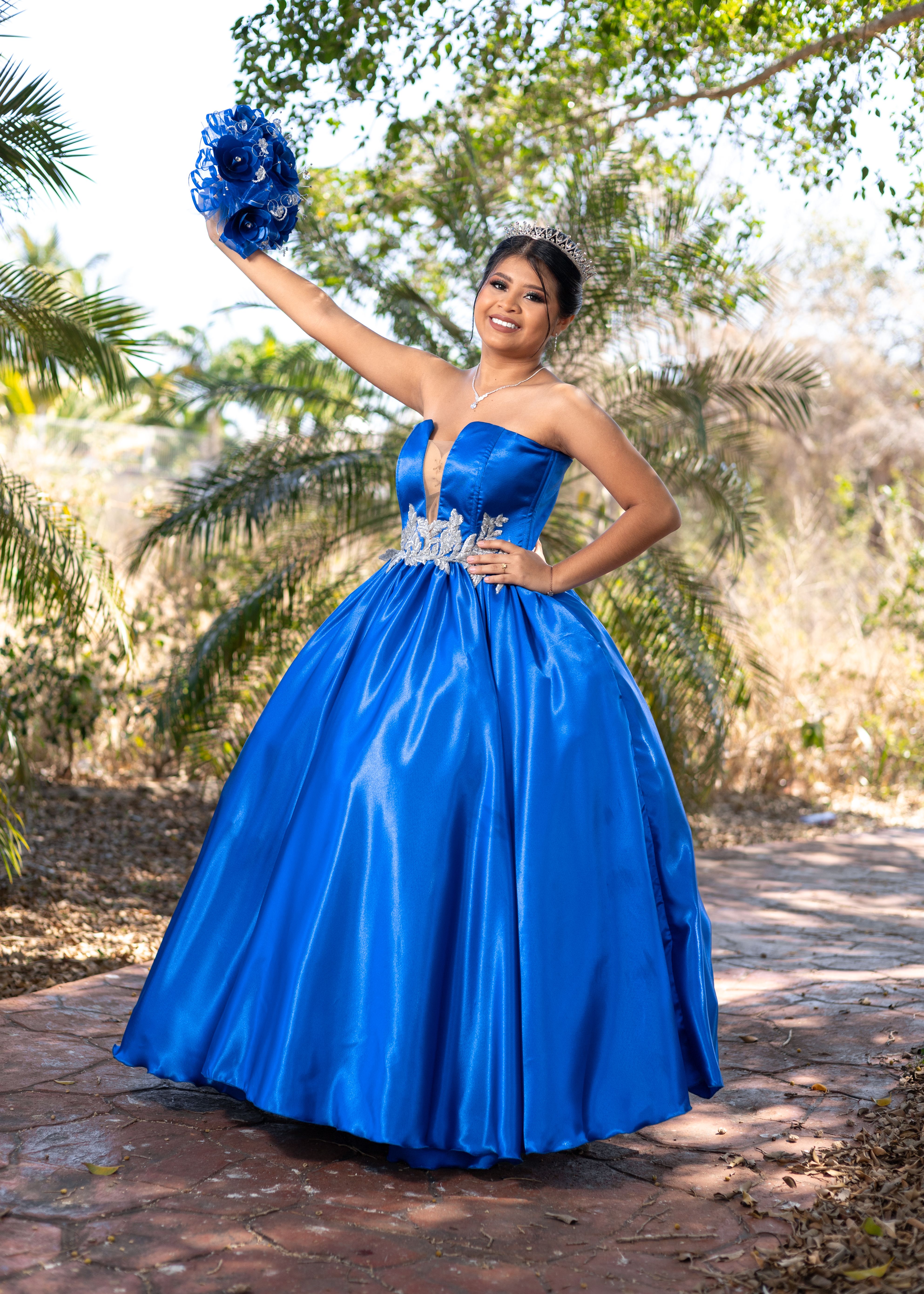 Smiling Woman in Blue Gown Posing in front of Palm Trees · Free Stock Photo