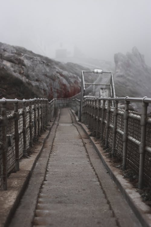 A walkway leading to a cliff with fog