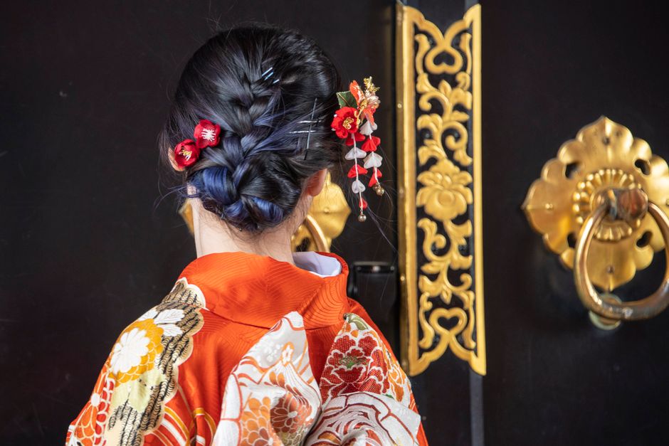 Close-up of a woman in traditional Japanese kimono with floral hairpins, showcasing cultural elegance.