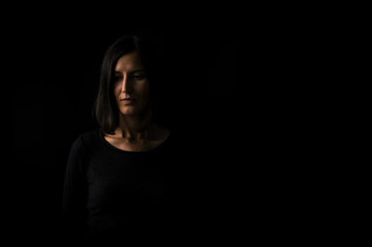 这幅在弱光下拍摄的迷人女性肖像，营造出戏剧性而神秘的氛围