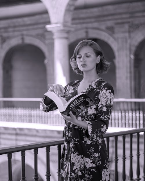 Free A woman in a floral dress is reading a book Stock Photo