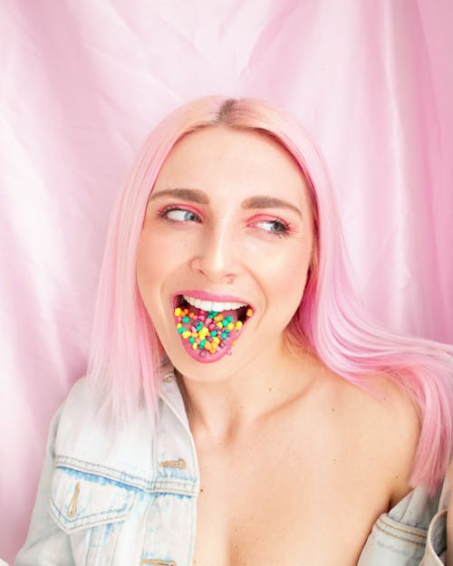 모듬 된 색 사탕으로 그녀의 혀를 보여주는 여자