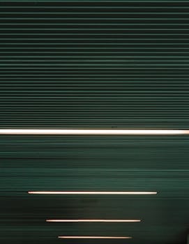 现代天花板的抽象视图，采用线性灯光和深色色调