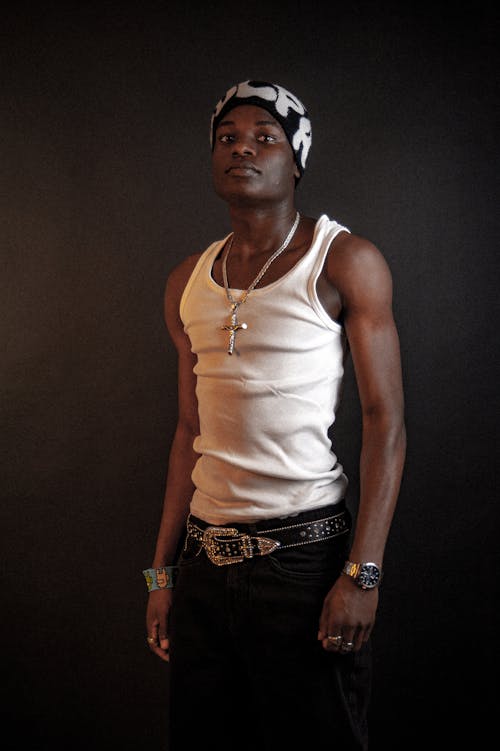 Standing Man in Beanie Hat, Tank Top and Jeans with Ornate Belt