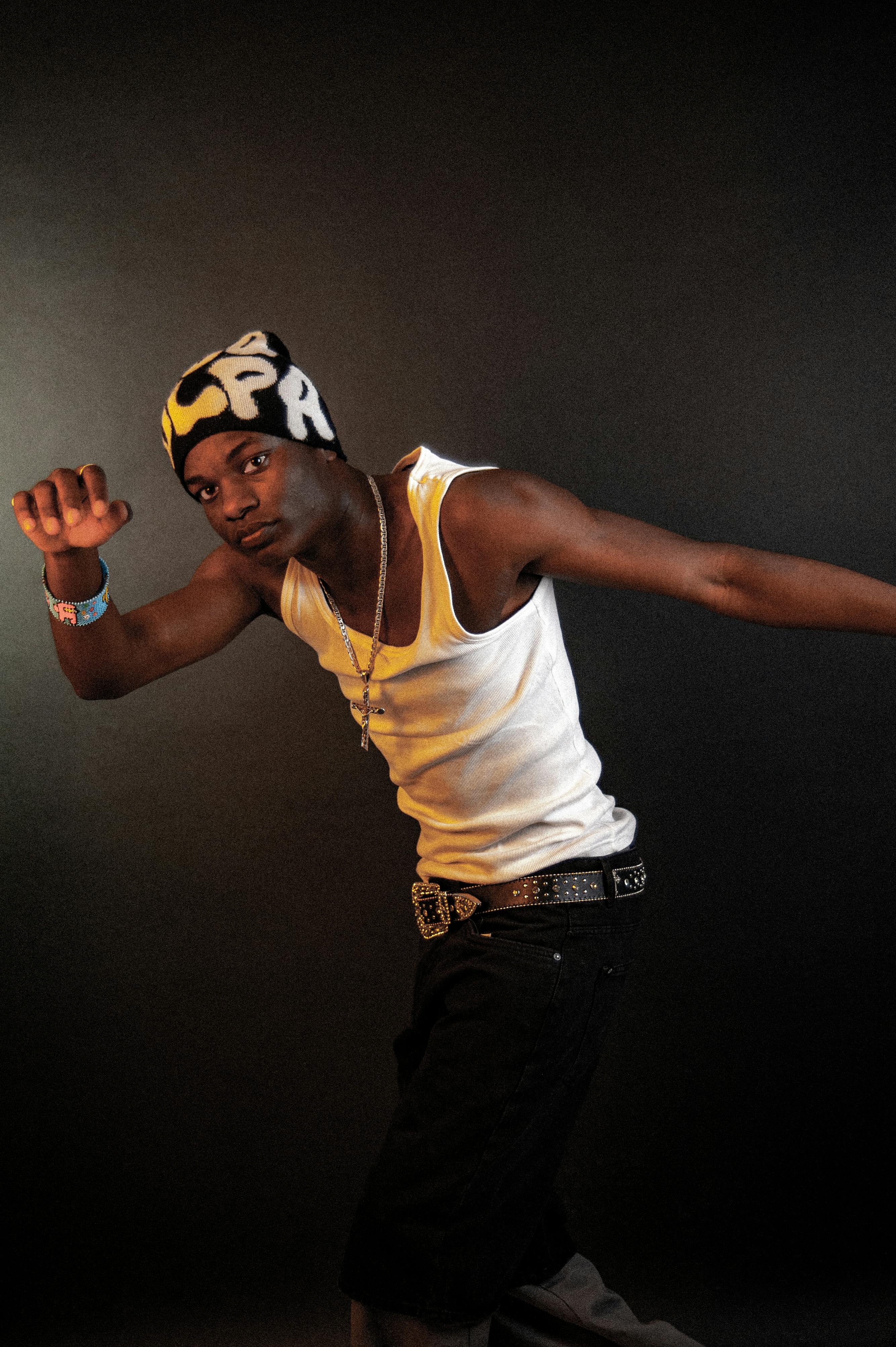 Dynamic portrait of a young man posing in a studio, showcasing urban fashion in Berlin.