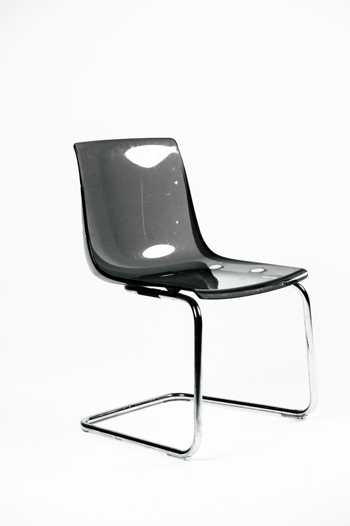Smoked polycarbonate cantilever chair on a white ground, photo by Sydney Sang on Pexels