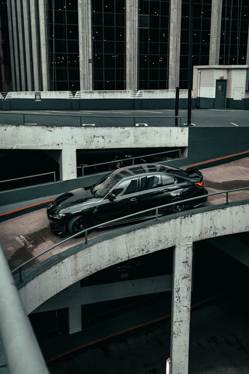 A black car is parked on a bridge