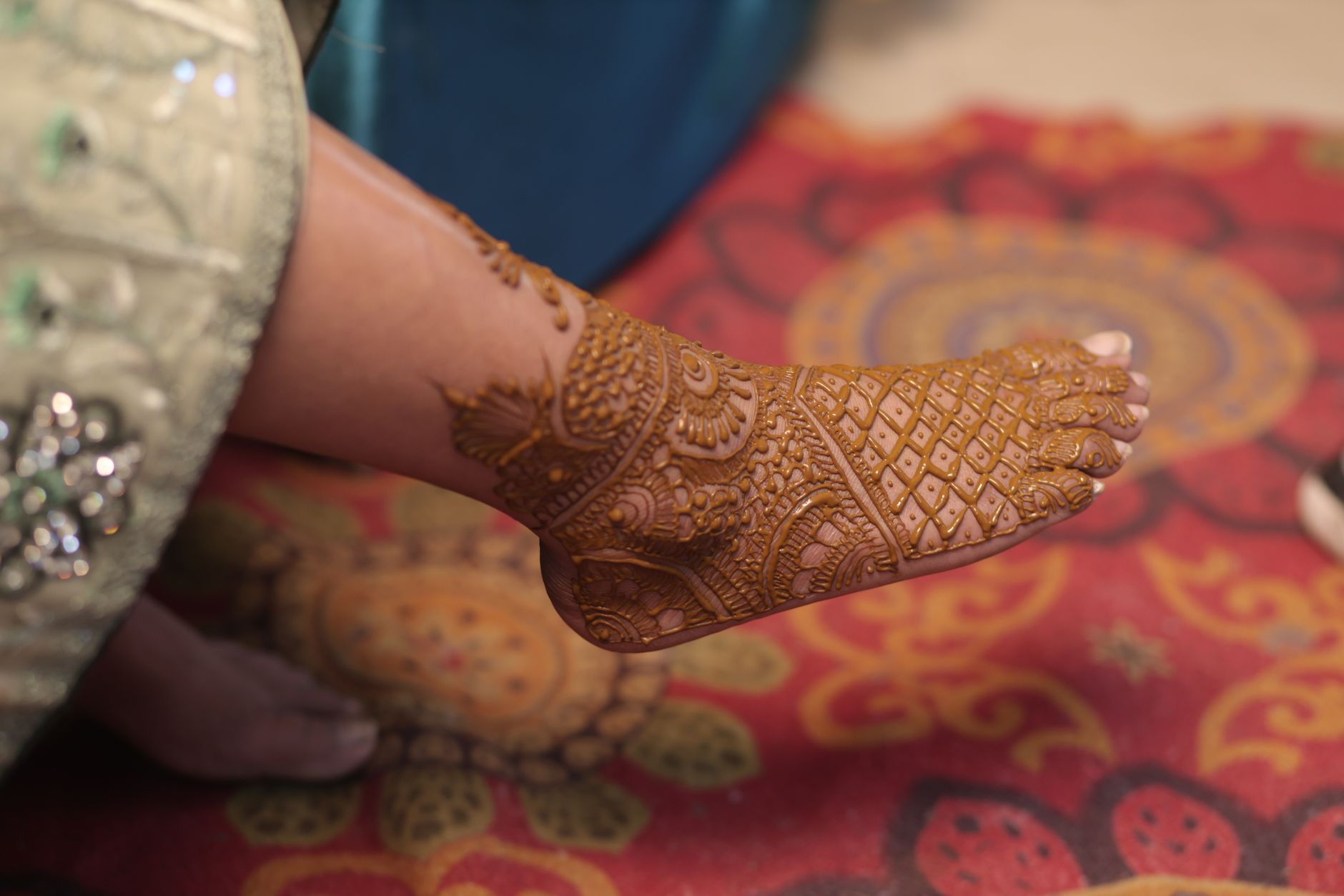 Close-up of traditional henna patterns adorning a bride's foot for an Indian wedding ceremony.