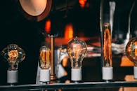 一系列老式爱迪生灯泡发出温暖的光芒，展现出复杂的灯丝结构