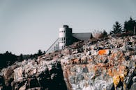 现代建筑房屋坐落在晴朗天空下的戏剧性岩石悬崖上