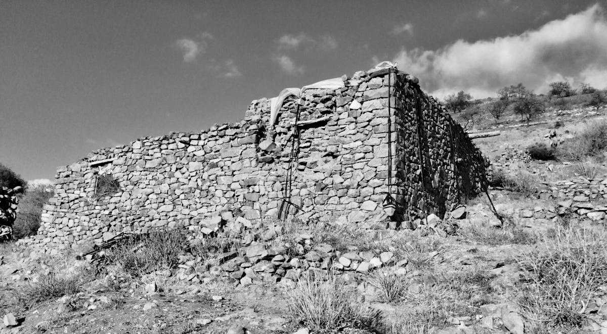 Historic stone buildings of Nelson's Dockyard in English Harbour, Antigua, set against lush green hills and a calm sailing marina