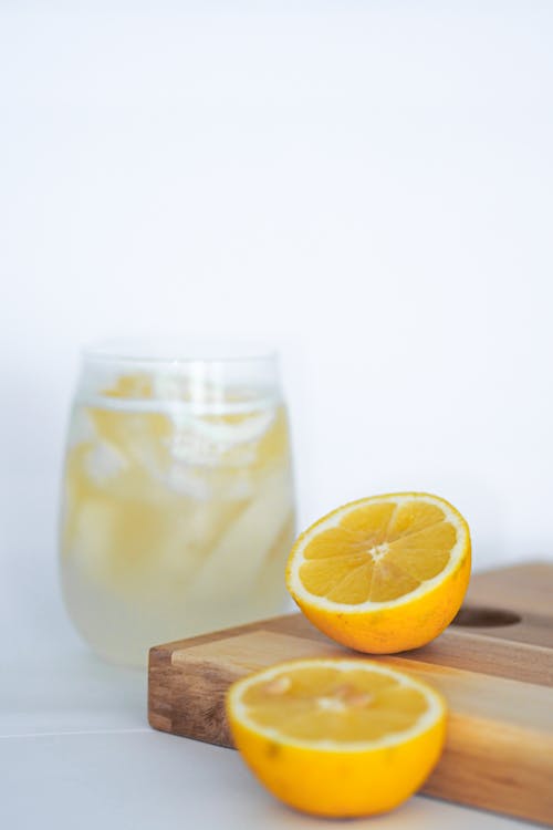 Free A glass of lemonade with a slice of lemon on a cutting board Stock Photo