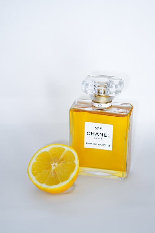 A bottle of chanel perfume with a lemon