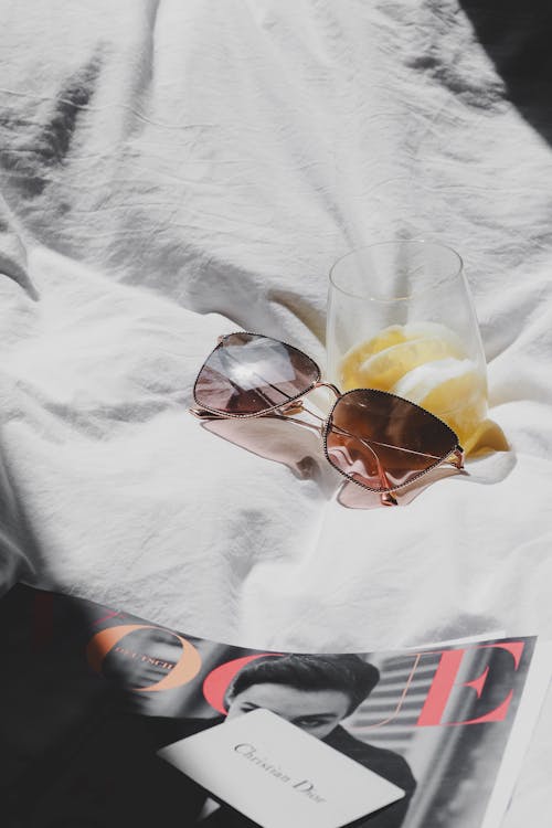 Free A magazine with sunglasses and a glass of orange juice Stock Photo