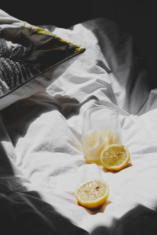 Free Lemon slices on a bed with a glass of water Stock Photo