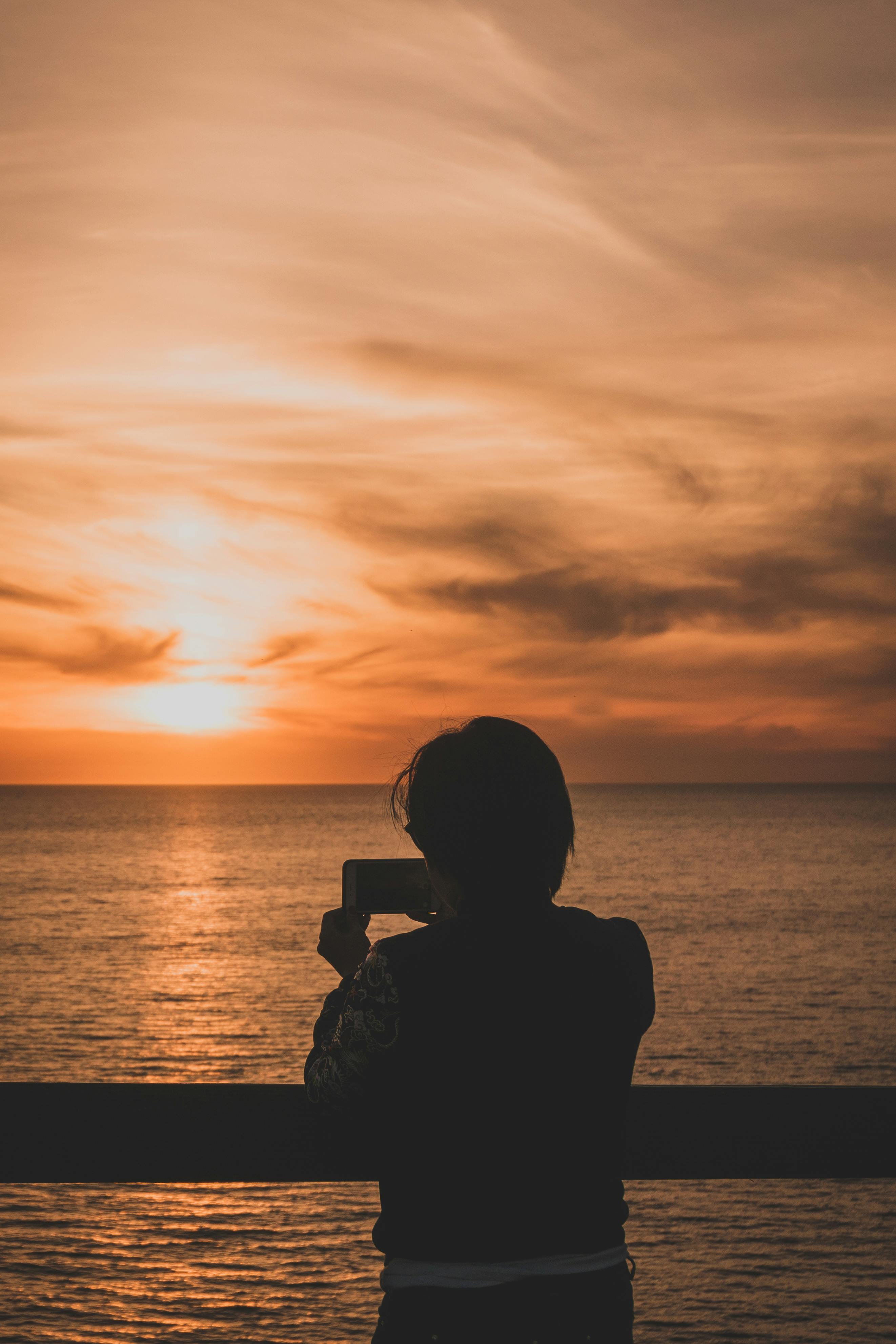 在加利福尼亚州帕洛斯维德斯牧场，一个人拍摄了海洋上令人惊叹的日落剪影