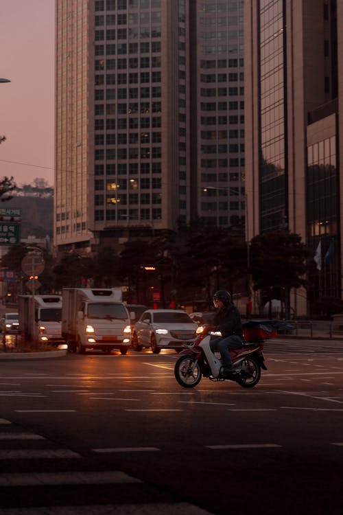 Free A person riding a motorcycle on a city street Stock Photo