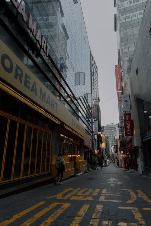 A street with yellow and black signs and people walking