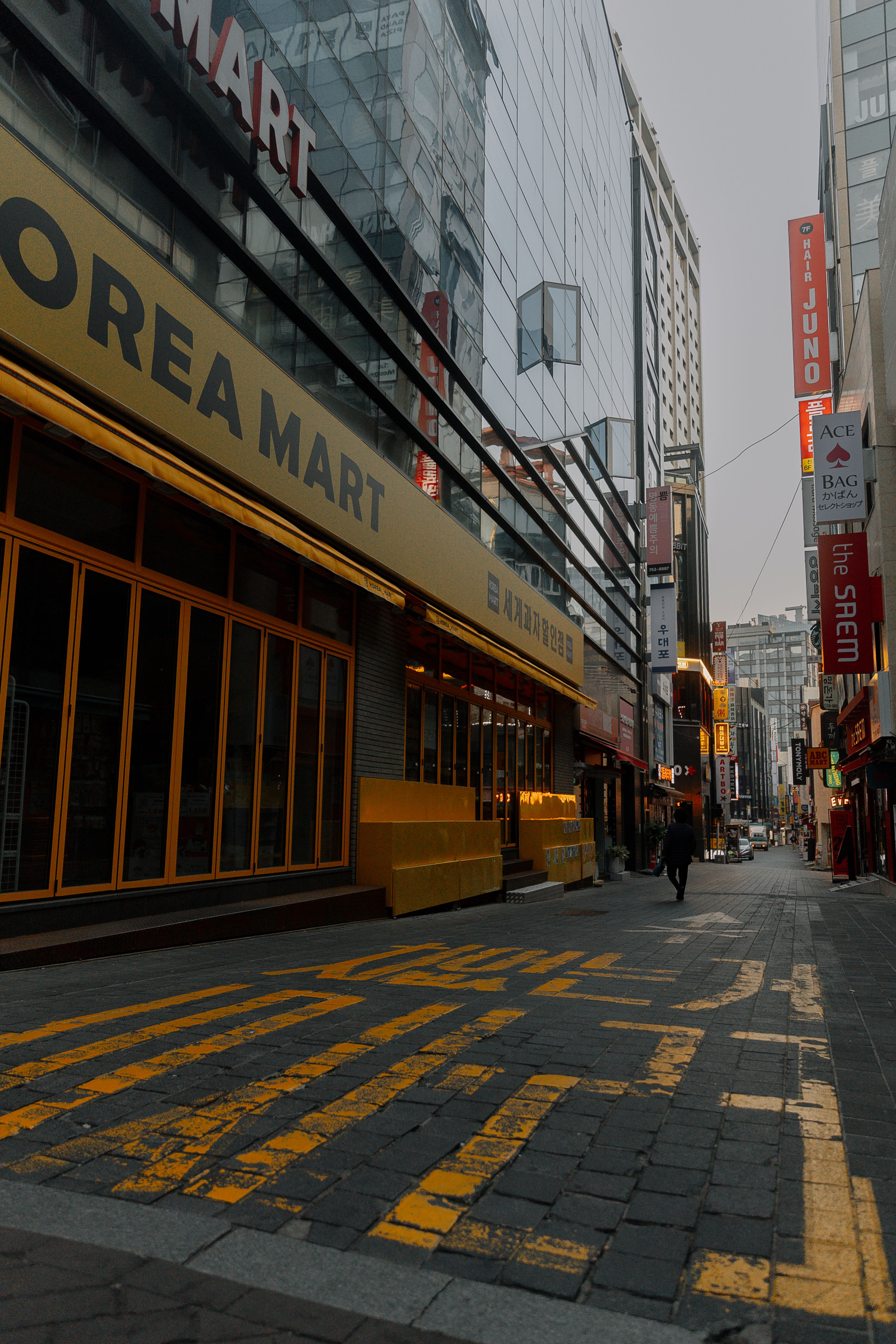 Explore an urban street scene in Seoul featuring Korea Mart with modern architecture and vibrant urban life.