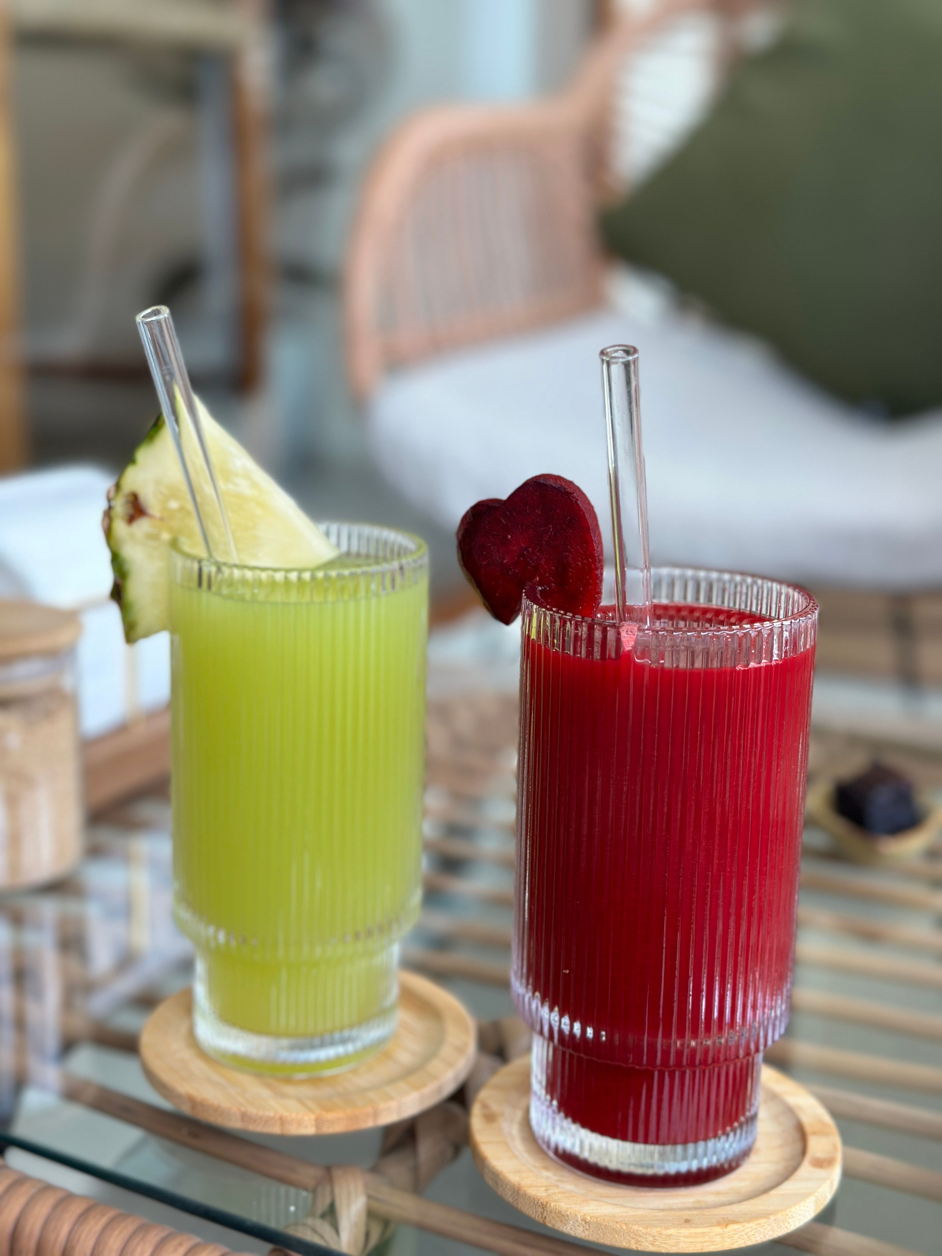 Close-up of cold drinks in glasses with coasters on an indoor table