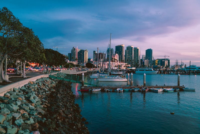 Photo crépusculaire de la marina de San Diego avec skyline et bateaux.