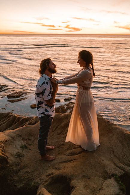 A couple shares a romantic moment by the ocean at sunset in San Diego, California.