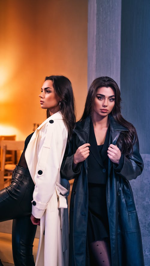 Two women in black leather coats standing next to each other