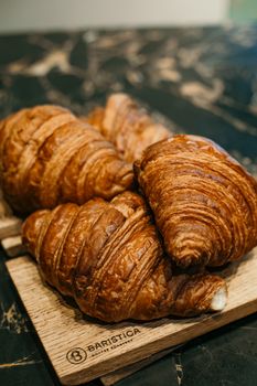 Delicious croissants on a rustic board, perfect for breakfast or a sweet treat.