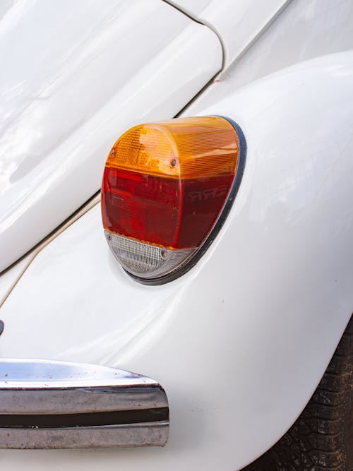 A close up of the front end of a white vw beetle