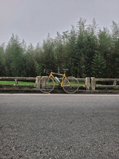 A yellow bicycle parked on the side of the road