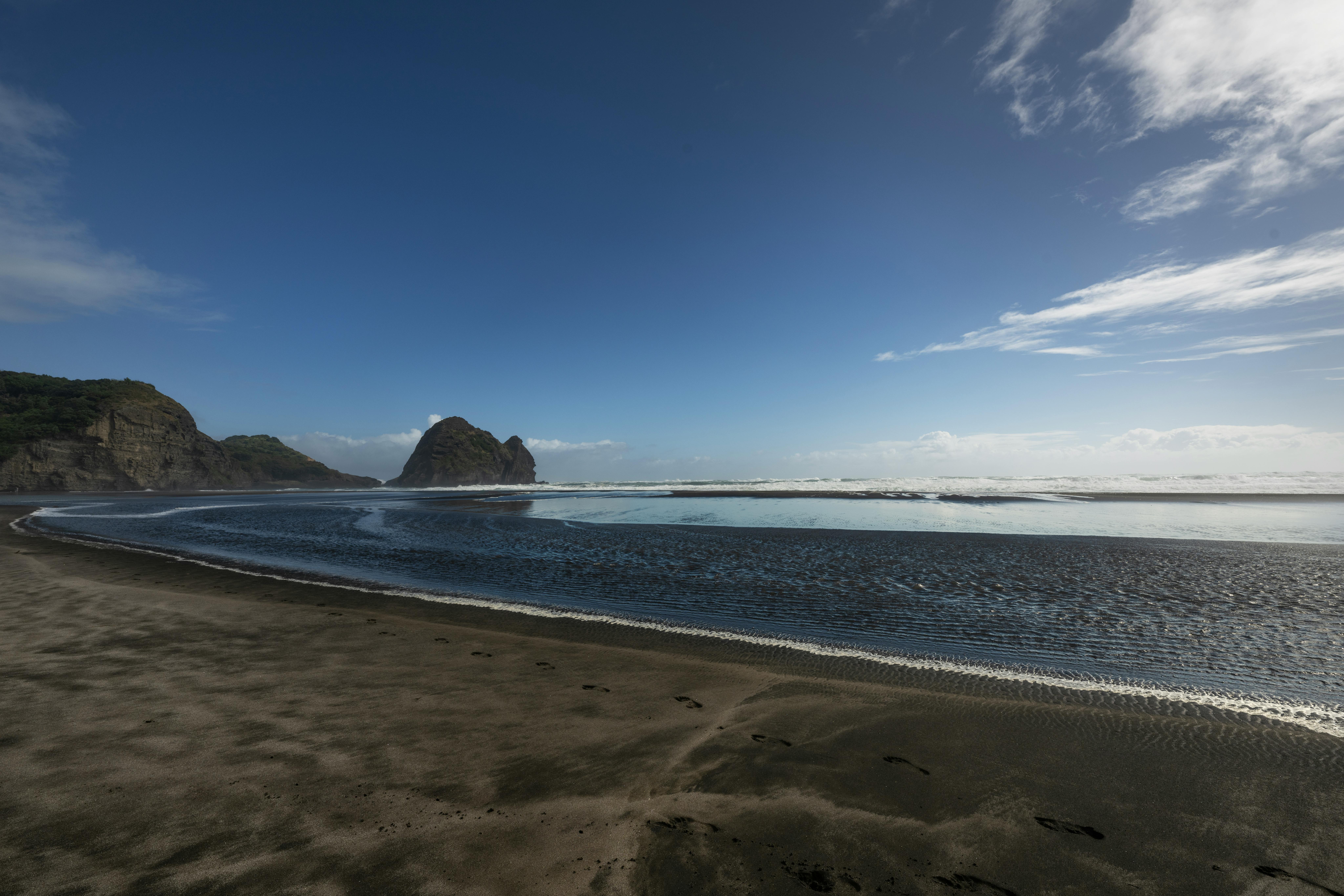 Beautiful coastal landscape with rocks and ocean under a clear sky.