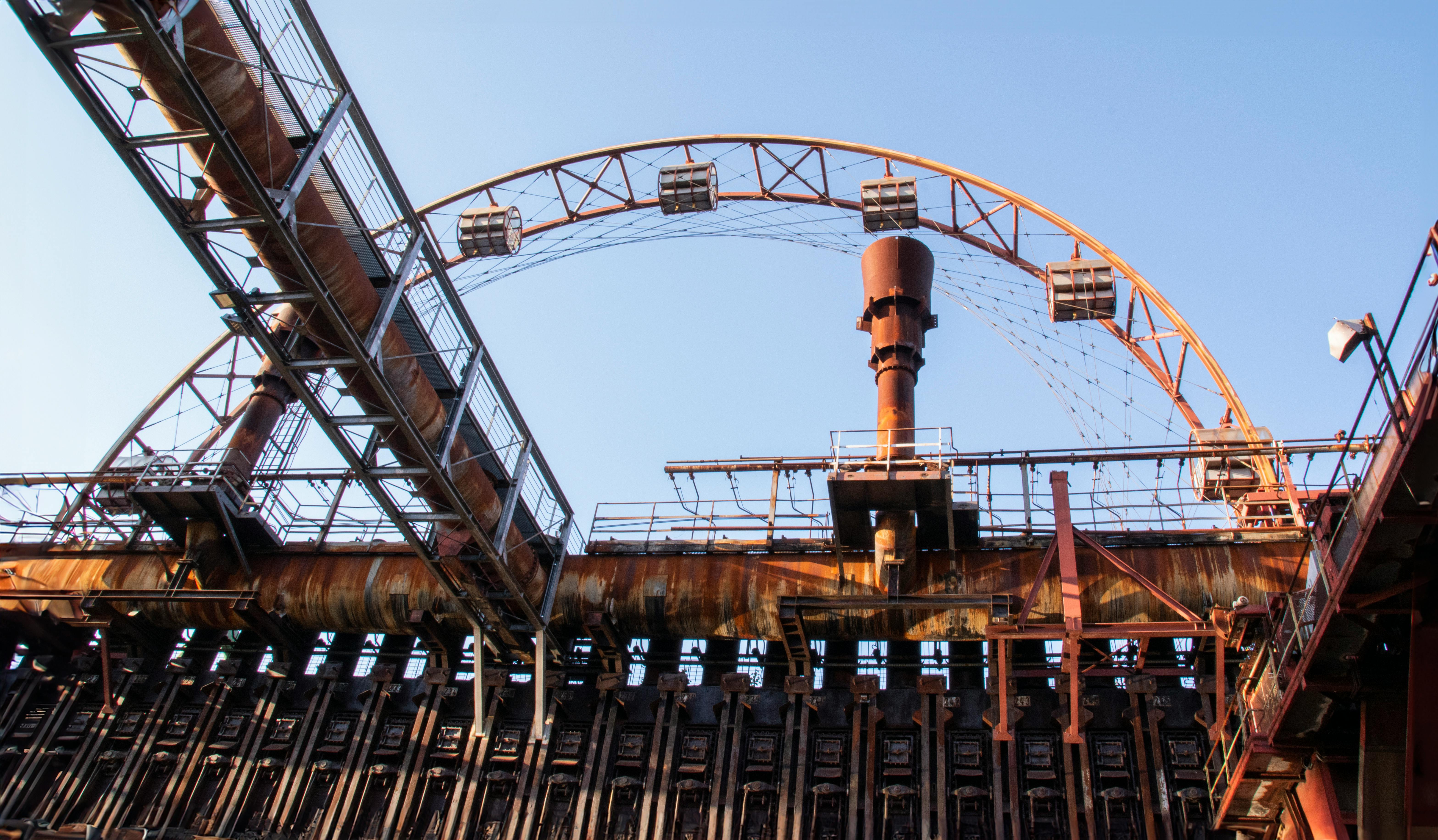 Kostenlos Eine verrostete Industrieanlage vor strahlend blauem Himmel in Zollverein, Essen. Stock-Foto