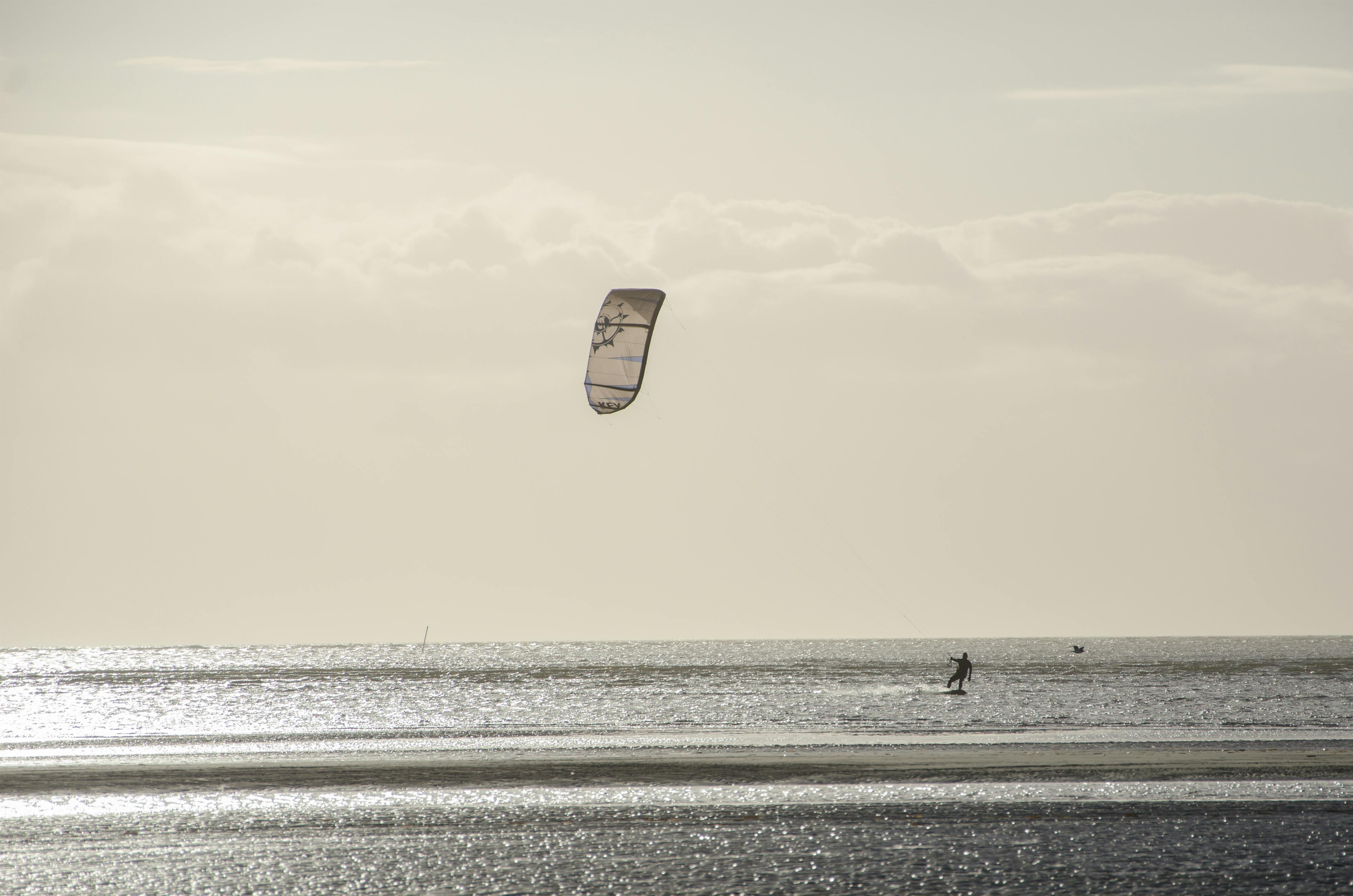 person parasailing under cloudy sky